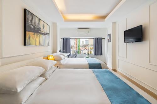 una habitación de hotel con dos camas y un televisor de pantalla plana en Bến Thành Market - KAS HOTEL, en Ho Chi Minh