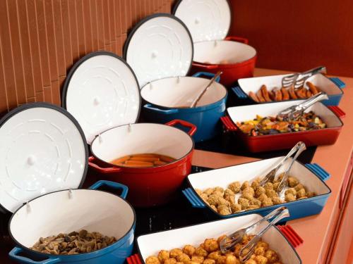 a buffet of different types of food in buckets at TRIBE Budapest Airport in Budapest
