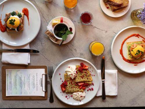 uma mesa com pratos de comida e um copo de vinho em Swissôtel Damian Jasna em Demanovska Dolina