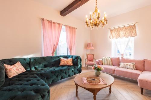 un salon avec un canapé vert et une table dans l'établissement Maison de L'Apothicaire, à Montaigu-Vendée