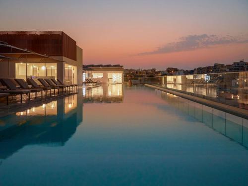 a swimming pool on the roof of a building at Novotel Malta Sliema in Il-Gżira