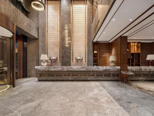 un hall avec un long banc dans un bâtiment dans l'établissement Grand Mercure Kunming South, à Kunming