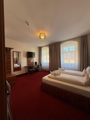 a hotel room with a large bed and a desk at Hotel Schwibbogen Altstadt & Apartments in Görlitz