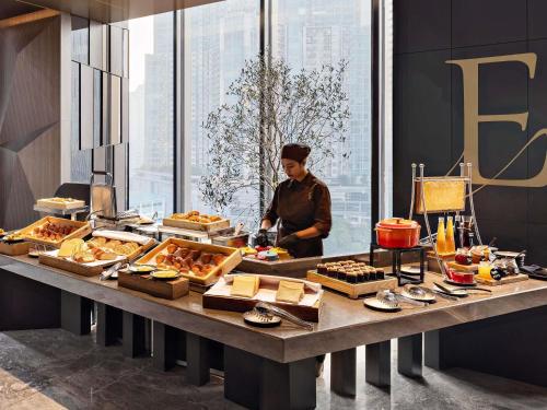 a man standing in front of a buffet of food at Swissôtel Living Jakarta Mega Kuningan in Jakarta