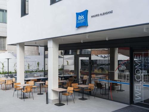 a group of tables and chairs outside of a restaurant at ibis budget Madrid Albasanz in Madrid