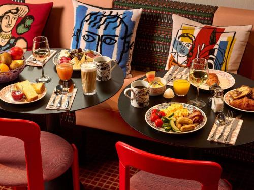 a table with plates of food and glasses of wine at Mama Shelter Zurich in Zürich