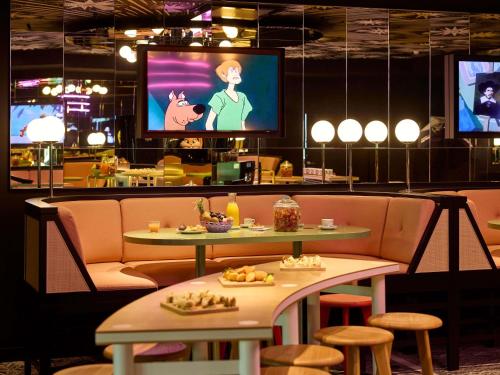 a restaurant with two tables and a flat screen tv at Mama Shelter Zurich in Zürich