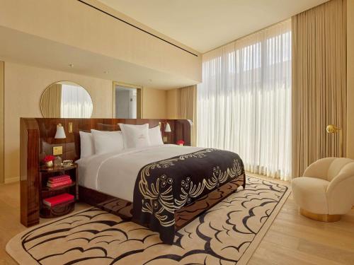 Un dormitorio con una cama grande con una ventana grande. en Faena New York, en Nueva York