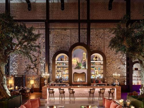 Un vestíbulo con chimenea, mesas y sillas. en Aliée Istanbul - A Paris Society Collection Hotel, en Estambul