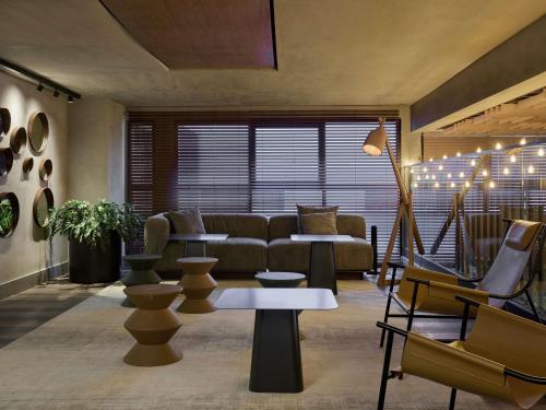 ein Wohnzimmer mit Couch und Stühlen in der Unterkunft TRIBE Belo Horizonte Savassi in Belo Horizonte