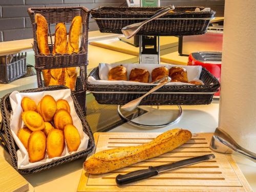 dos cestas de pan y pastas en una barra en ibis Styles Chartres Sud Barjouville, en Chartres