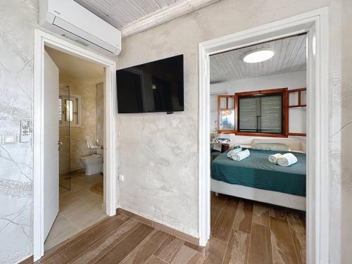 - une chambre avec un lit, une télévision et une salle de bains dans l'établissement Villa Kristina, Ermioni, à Plépi