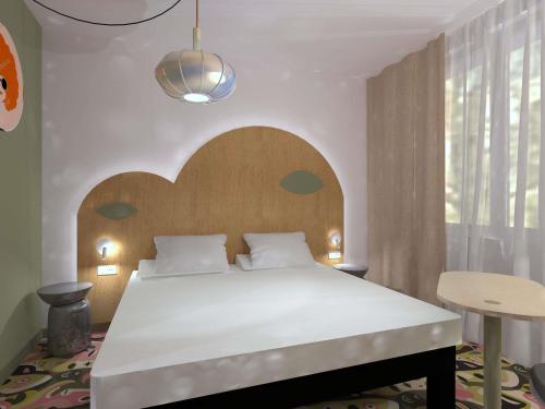 Un dormitorio con una cama grande con cabecero de madera. en ibis Styles Metz Centre, en Metz