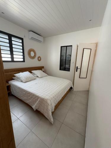 a bedroom with a bed and a window at Villa O'CAMPÊCHE in Rivière-Salée