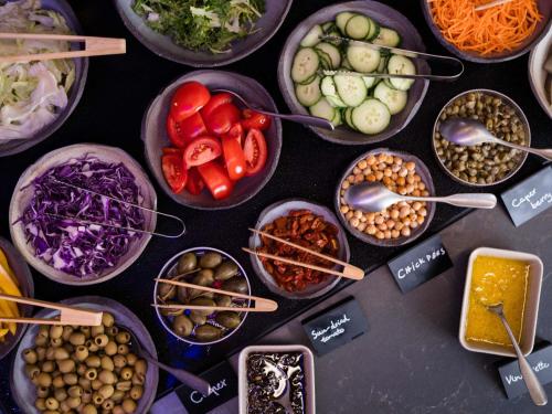 a table topped with bowls of different types of food at You Hotel Budapest - Handwritten Collection in Budapest