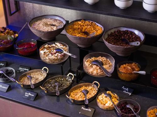 a display of different types of food in bowls and spoons at You Hotel Budapest - Handwritten Collection in Budapest