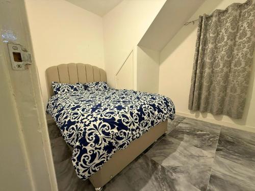 une chambre avec un lit avec une couette bleue et blanche dans l'établissement Modern 2 bedrooms Apartment- Ashton-Under-Lyne- Hosts 5 persons, à Ashton-under-Lyne