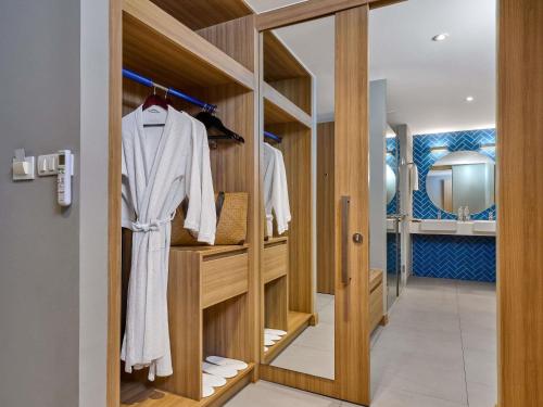 - un dressing avec un peignoir et un miroir dans l'établissement Mercure Phuket Patong Journeyhub, à Patong Beach