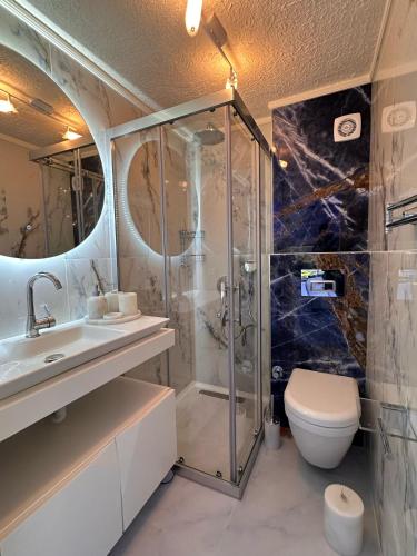 a bathroom with a shower and a toilet and a sink at Seaview Holiday Home Kalkan in Kalkan
