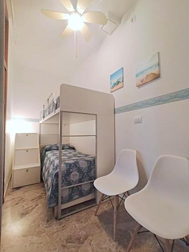 a bedroom with a bunk bed and two white chairs at Trilocale vacanza Riccione in Riccione