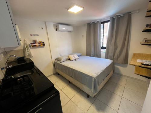 ナタールにあるPrático 228の小さなベッドルーム(ベッド1台付)、キッチンが備わります。