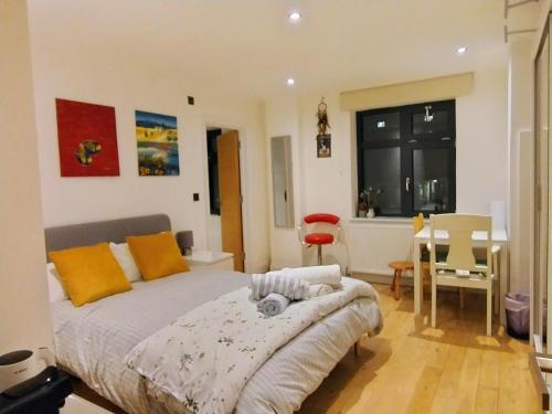 a bedroom with a bed and a table and a chair at Fantastic location private Deluxe Ensuite bathroom Shoreditch Hoxton spitalfields Liverpool st London Bridge city 2 Rooms luxury Doubles for 5 guests in London