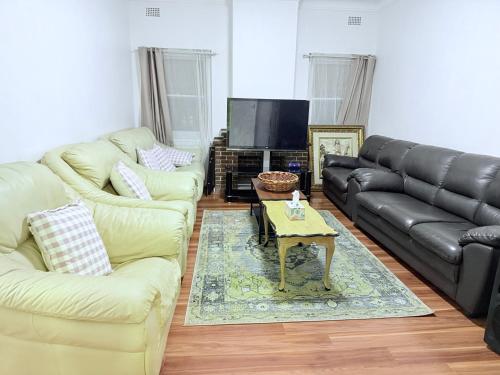 a living room with two couches and a coffee table at Spacious Luxe Rooms - Prime location in Earlwood & close to shops in Sydney