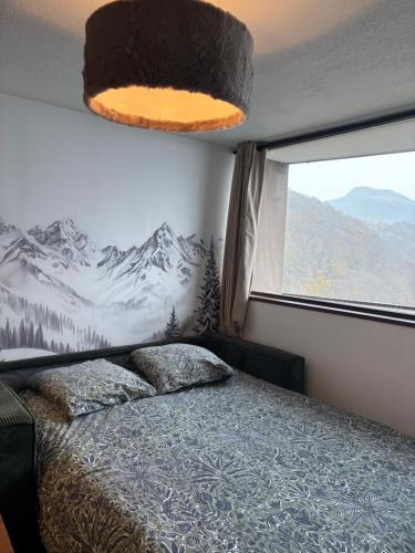 Schlafzimmer mit einem Bett und einem Fenster mit Bergblick in der Unterkunft Mountain&View in Super Besse