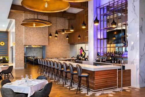 Un restaurante con mesas y sillas y un bar. en CIRC Hotel By Hosteeva, en Hollywood