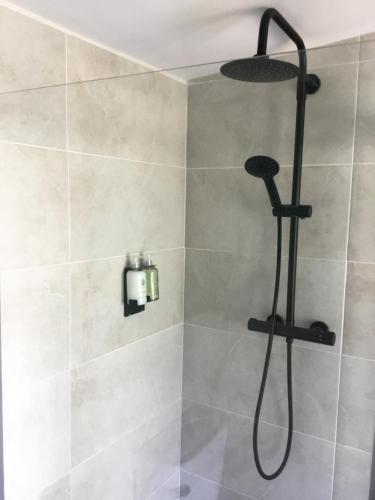 a shower with a shower head in a bathroom at The Cosy Nest Hut in Keddington