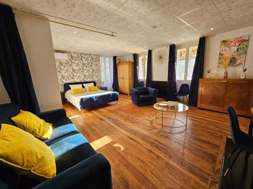 una sala de estar con un sofá y una cama en LE MANOIR- CLUNY, en Cluny