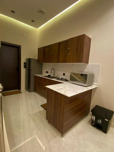 a kitchen with wooden cabinets and a counter top at albaha harmony resort in Al Baha