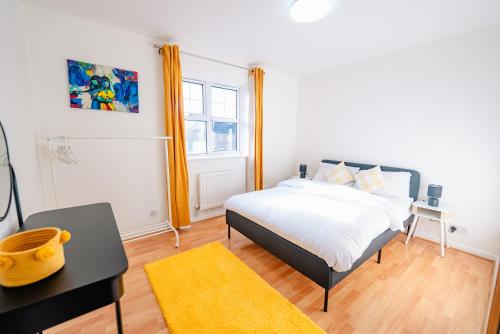 une chambre avec un lit et un bureau dans l'établissement Spacious & High celling 2 Bedroom House, à Cardiff