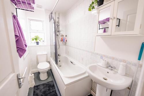 une salle de bain blanche avec un lavabo et des toilettes dans l'établissement Spacious & High celling 2 Bedroom House, à Cardiff
