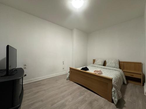 Un dormitorio con una cama y un televisor de pantalla plana. en Le Cocon Cathédrale, en Metz