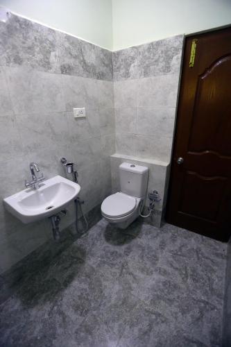 a bathroom with a toilet and a sink at Tulips Valley View Resorts in Ooty