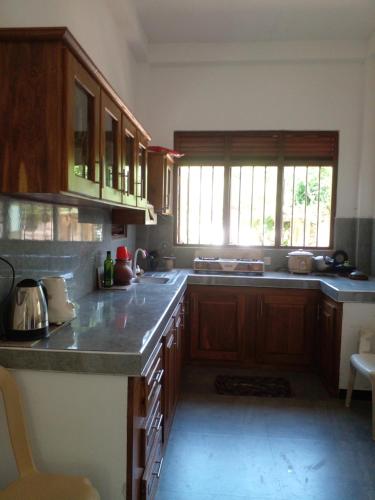 une cuisine avec des armoires en bois et un comptoir dans l'établissement Happy villa, à Weligama