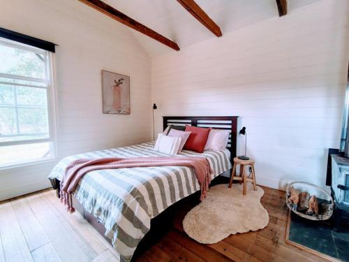 une chambre avec un lit avec une couverture rayée dans l'établissement Hanging Rock Farm Stay, à Newham