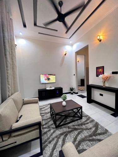 a living room with a couch and a ceiling fan at Ynna Stays in Dar es Salaam