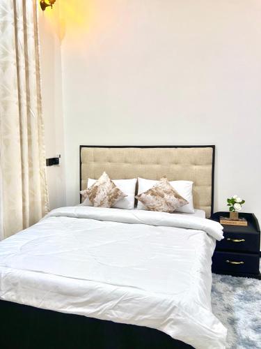 a bedroom with a bed with white sheets and pillows at Ynna Stays in Dar es Salaam