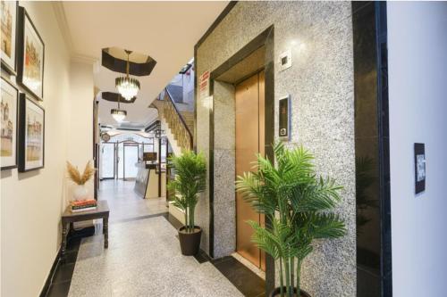 a hallway with potted plants in a building at FabHotel Delhi Continental in New Delhi