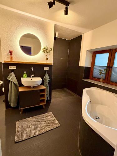 a bathroom with a tub and a sink and a bath tub at Ferien im Schwarzwald Dörlinbach II in Schuttertal