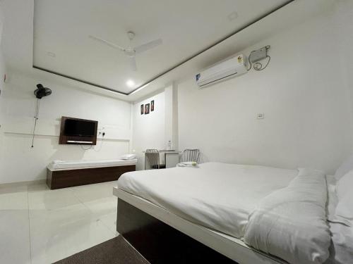 HatikhuliSneha Bhawan Kaziranga的白色的客房配有床和电视。