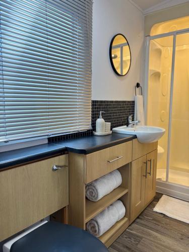 a bathroom with a sink and a mirror at Seven Bays Hideaway in Saint Merryn