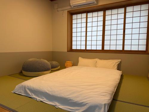 a bedroom with a large bed with two windows at Mori Sapporo in Sapporo