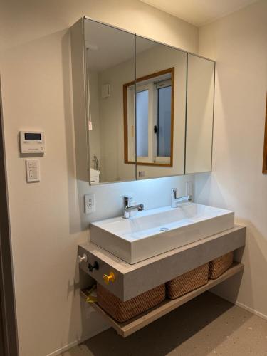 a bathroom with a white sink and a mirror at Mori Sapporo in Sapporo