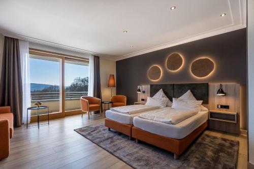 a bedroom with a large bed and a large window at Landhotel Heimathenhof in Heimbuchenthal