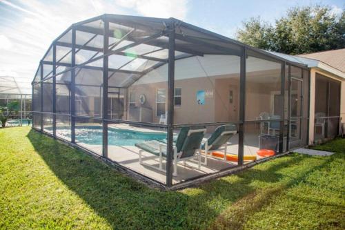 a glass house with a pool in the yard at Rocco's Retreat in Orlando