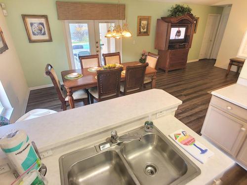 a kitchen and dining room with a sink and a table at Rocco's Retreat in Orlando