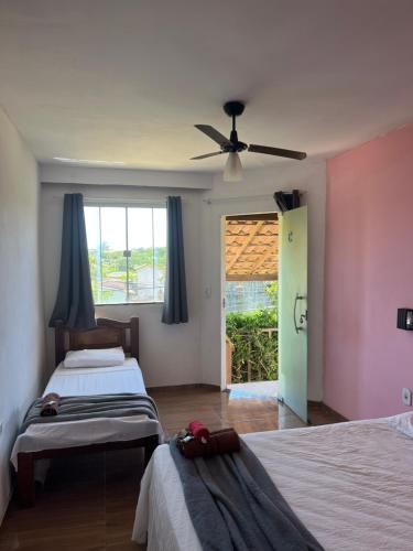 a bedroom with two beds and a ceiling fan at Renascer Suites in Búzios